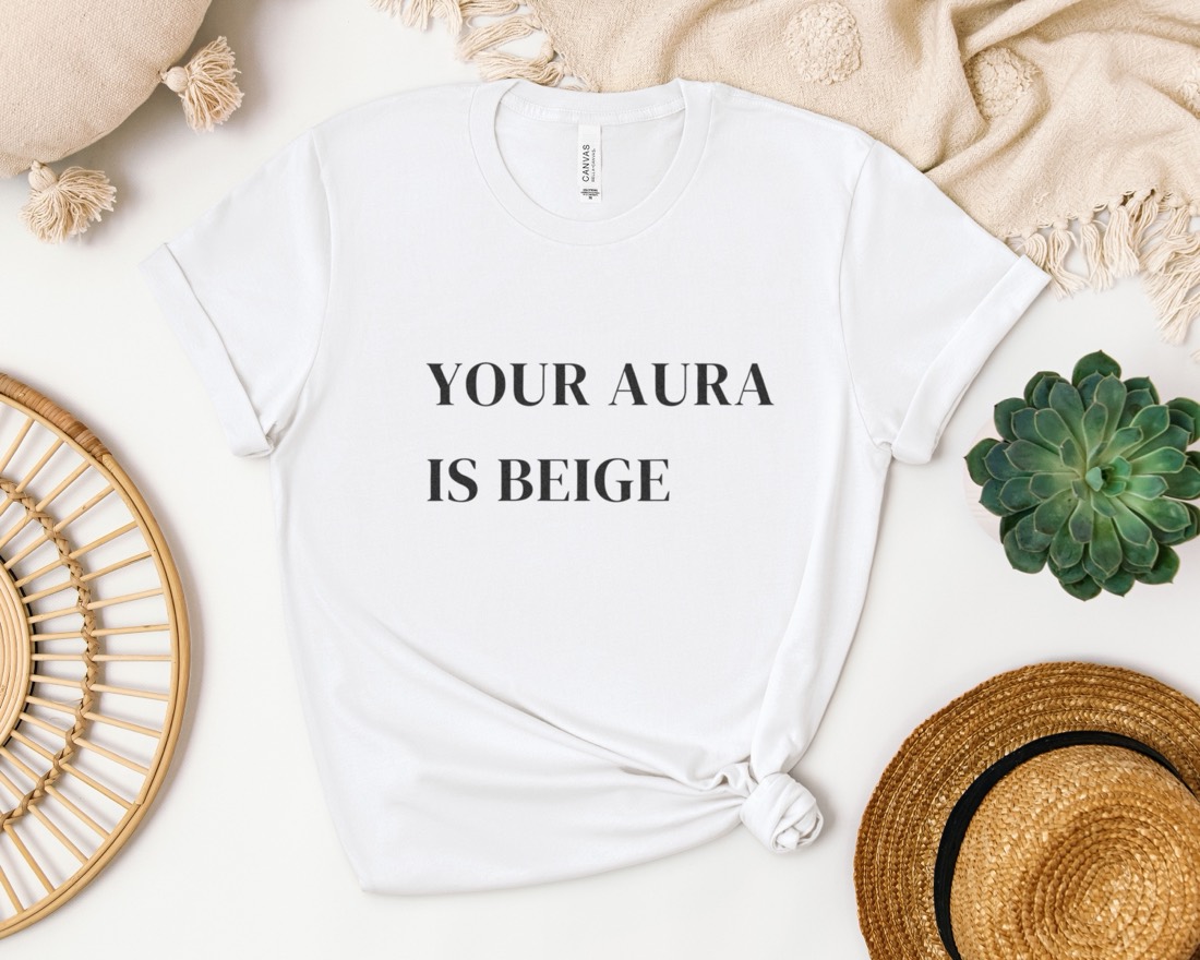 White Your Aura Is Beige tee laid flat with styled props